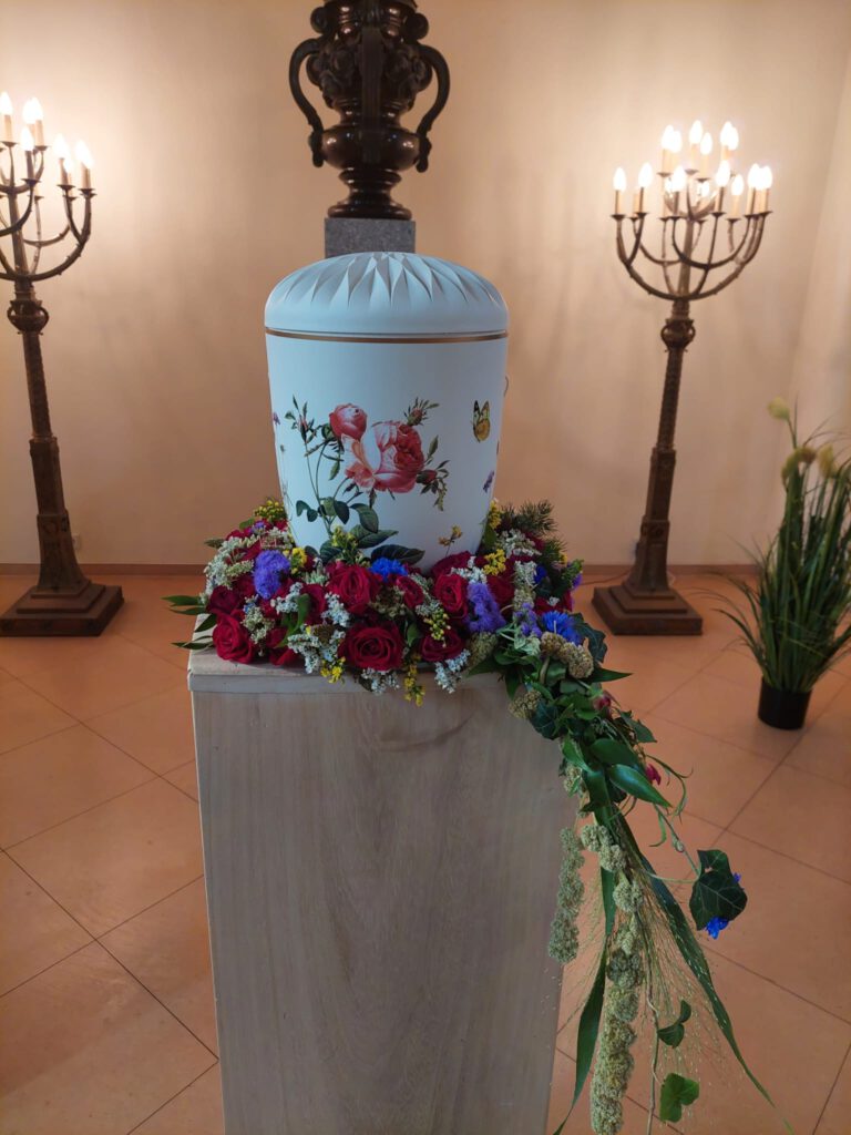 Liebevoll geschmückte Urne mit Blumen