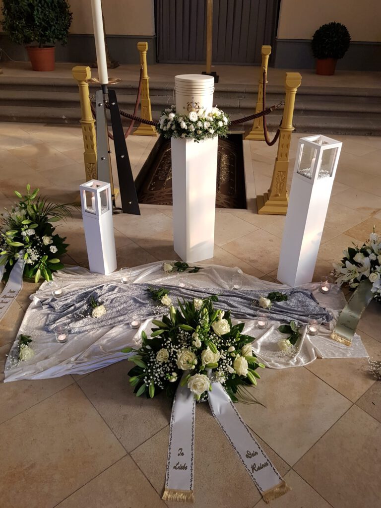 Kerzen und Blumenschmuck bei einer Trauerfeier